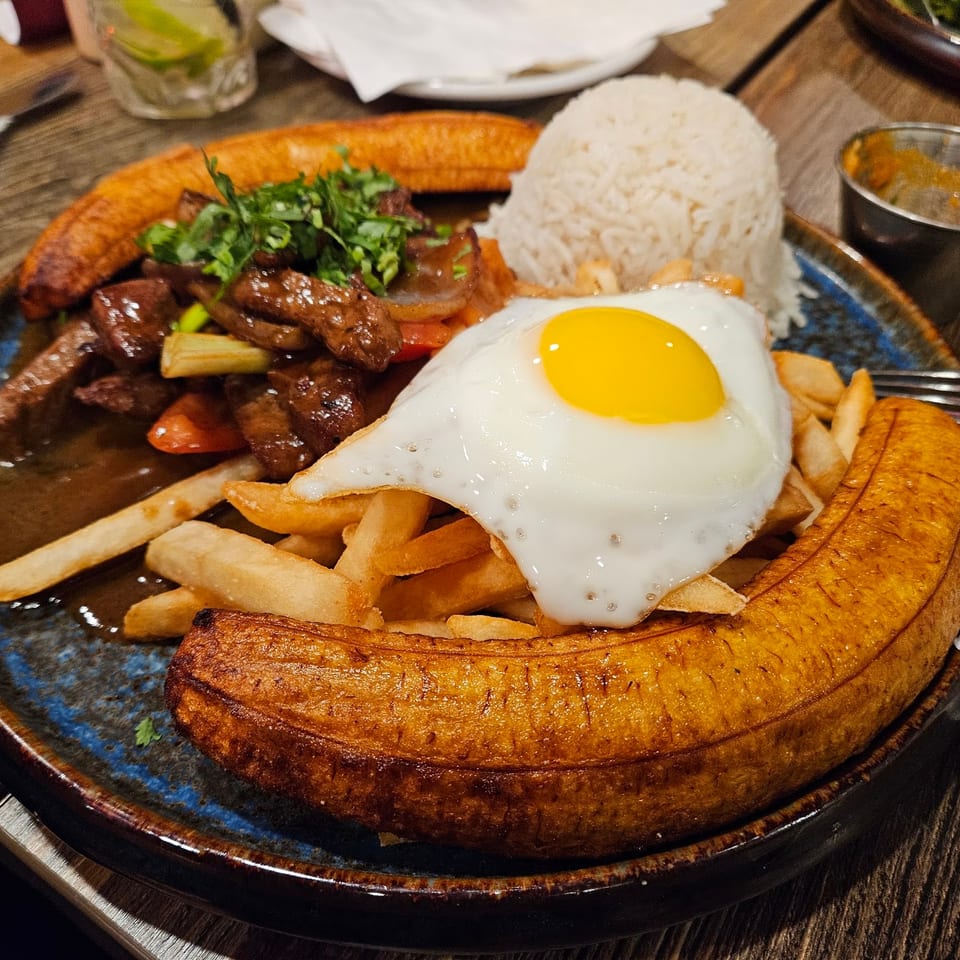 Lomo saltado with egg, rice and plantains